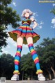 A woman in a colorful dress and striped tights posing for a picture.