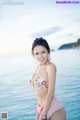 A woman in a pink bikini standing in the water.